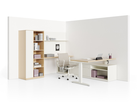 A Renew Sit-to-Stand Table placed perpendicular to a Canvas Private Office credenza, with a storage tower and shelves along the back wall.