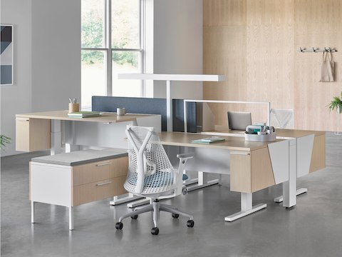 Canvas Vista benching application in the foreground and Canvas Vista desking application in the background, both with white and blue Sayl chairs.