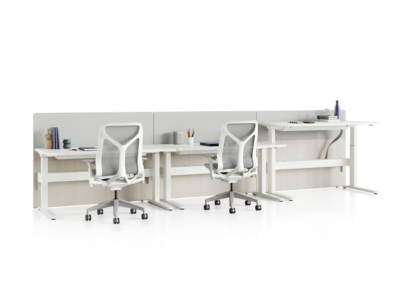 Standing desk system, Renew Link, with rectangular work surfaces, privacy screens, and Cosm Chairs. One of three desks is raised to standing height.