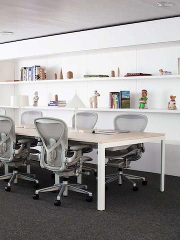 Fünf graue Aeron Stühle um einen Arbeitstisch im Showroom Mailand.
