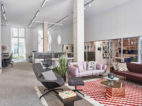 Lounge-Bereich im Showroom Paris mit Wireframe und Tuxedo Sofas sowie einem grauen Striad Sessel und Ottoman.