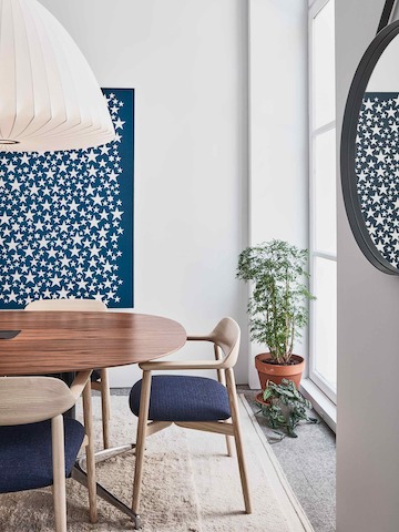 Sitzungsbereich im Showroom Paris mit Crosshatch Stühlen aus Holz um einem ovalen Civic Tisch mit Holzplatte.