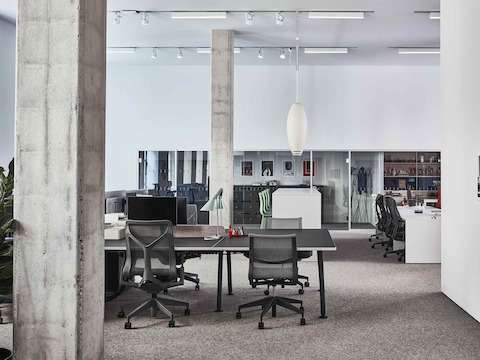 Arbeitsbereich im Showroom Paris mit Setu und Cosm Stühlen um einen schwarzen Memo Schreibtisch.