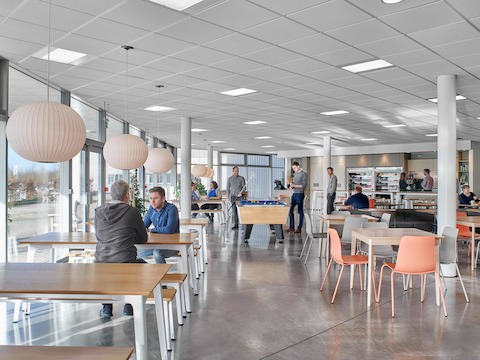 Una configurazione caffè arredata con tavoli da caffè, bench e sedie visitatore.