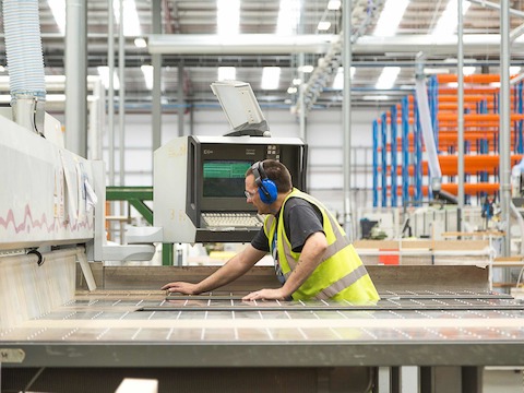 Foto dell’interno dello stabilimento di produzione di Herman Miller di PortalMill, con un dipendente che indossa un giubbotto di sicurezza.