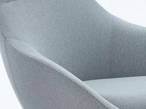 Detail of a chair with light blue woven fabric.
