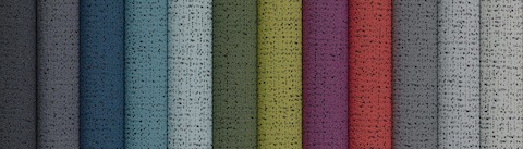 A top view of multiple, folded colorful and neutral fabrics.
