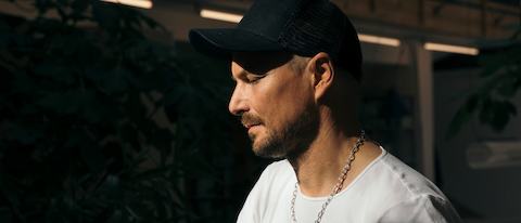 A headshot of designer Stefan Diez of Diez Office standing at a table.