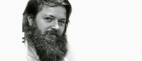 A black and white headshot of designer Ray Wilkes. Viewed at a three-quarter front angle.