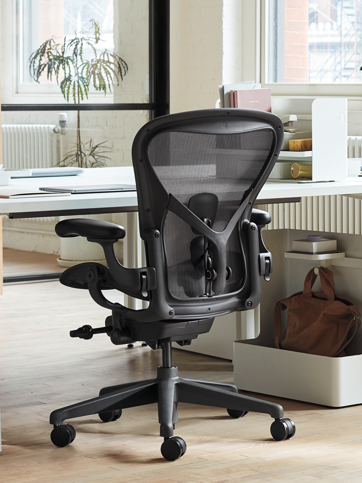 Ein Aeron Stuhl an einem Schreibtisch in einem Bürobereich.
