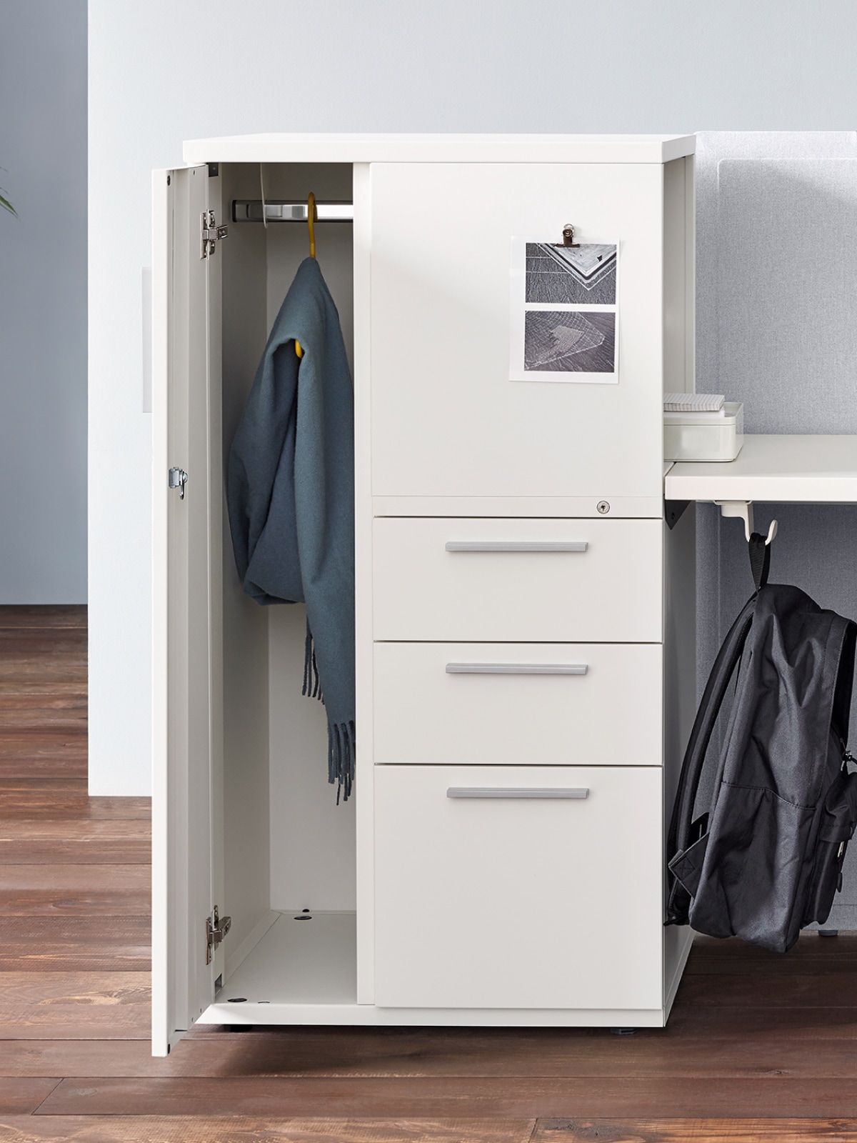 Ein weißer Tu Ablageschrank aus Metall mit offener Tür und drei geschlossenen Schubladen.