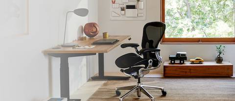 Aeron-Heimbürostuhl an einem Steh-Sitz-Schreibtisch
