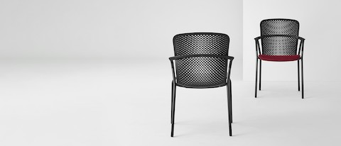 Two black Keyn side chairs facing each other. One chair has a crimson seat and the other a black seat.