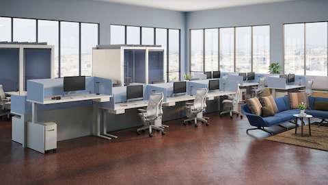 Workspace setting with Canvas Channel with blue Ambit fabric screens, small suspended storage, and mobile storage. , private Overlay work areas, and soft lounge area.
