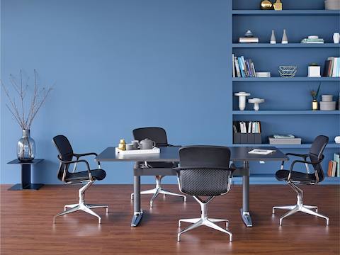 Quatre chaises Keyn entourent une table rectangulaire Atlas Office Landscape avec un dessus noir.