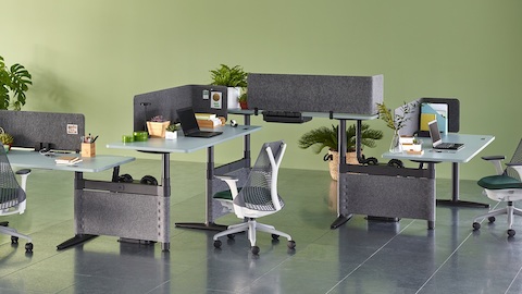 Les fauteuils de bureau Sayl complètent la configuration en zigzag de quatre bureaux Atlas Office Landscape à hauteur réglable avec sommets bleus.
