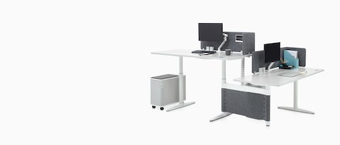 Atlas Office Landscape réglable en hauteur bureaux dans une configuration de 90 degrés, une à hauteur debout et une à la hauteur assise.