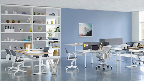 A collaboration setting featuring a cluster of sit-to-stand desks and a rectangular table from Atlas Office Landscape.