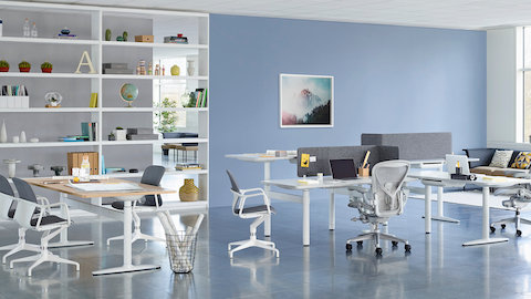 A collaboration setting featuring a cluster of sit-to-stand desks and a rectangular table from Atlas Office Landscape.