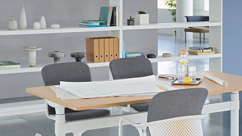 An open meeting space featuring a height-adjustable Atlas Office Landscape table and three gray Keyn chairs.