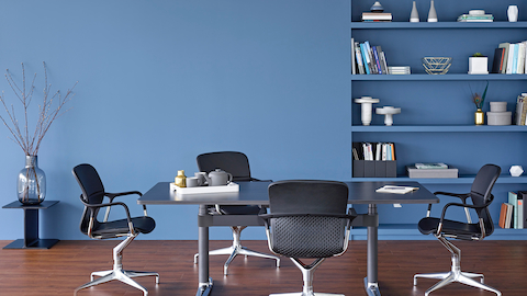 Four Keyn side chairs surround a rectangular Atlas Office Landscape table with a black top.