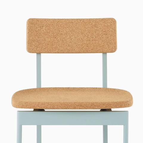 A Betwixt Chair with a cork seat and backrest with a glacier frame. 