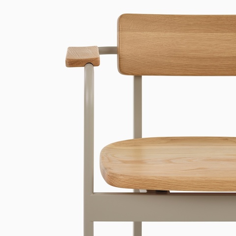 A close up of the front of a Betwixt Chair with oak seat and backrest with a grey frame. 