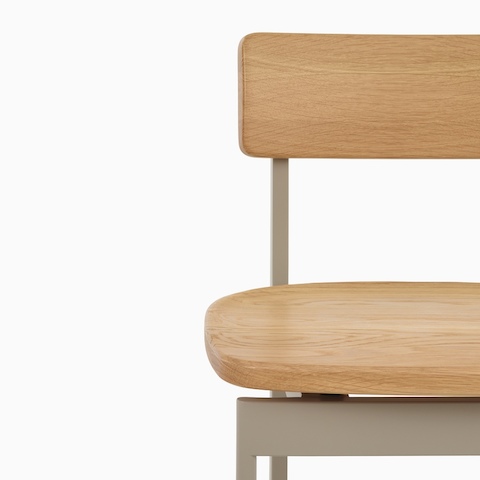 A close up of the front of a Betwixt Chair with oak seat and backrest with a grey frame. 