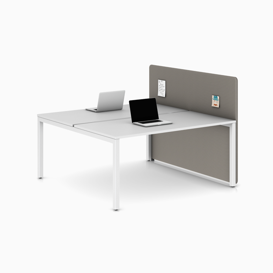 Eine hellbraune Galerietrennwand, montiert an einem weißen Layout Studio Arbeitsplatz mit zwei Arbeitsplatten, aus seitlichem Blickwinkel.