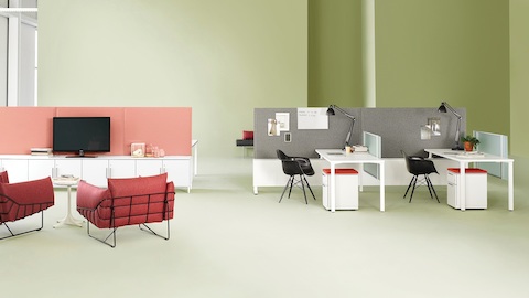 Canvas Dock setting with white desks, gray dividing screens, and black Eames Molded Fiberglass Chairs, located near a meeting space.