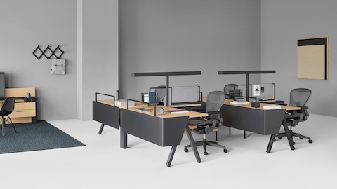 Canvas Vista workstations with black Aeron chairs in the foreground and Canvas Vista collaborative space with display unit in the background.