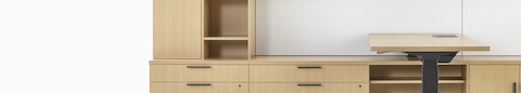 A close-up image of a Canvas Private Office with light wood storage and a height-adjustable desk.
