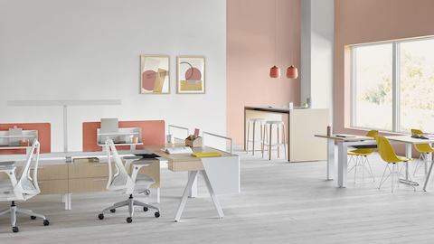 A Canvas Vista workstation in light wood and white with modesty screen, pink fabric screen, and gray Sayl office chairs.