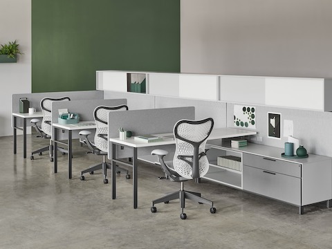A Canvas Wall workstation with grey screens, upper storage, and white Mirra 2 office chairs.