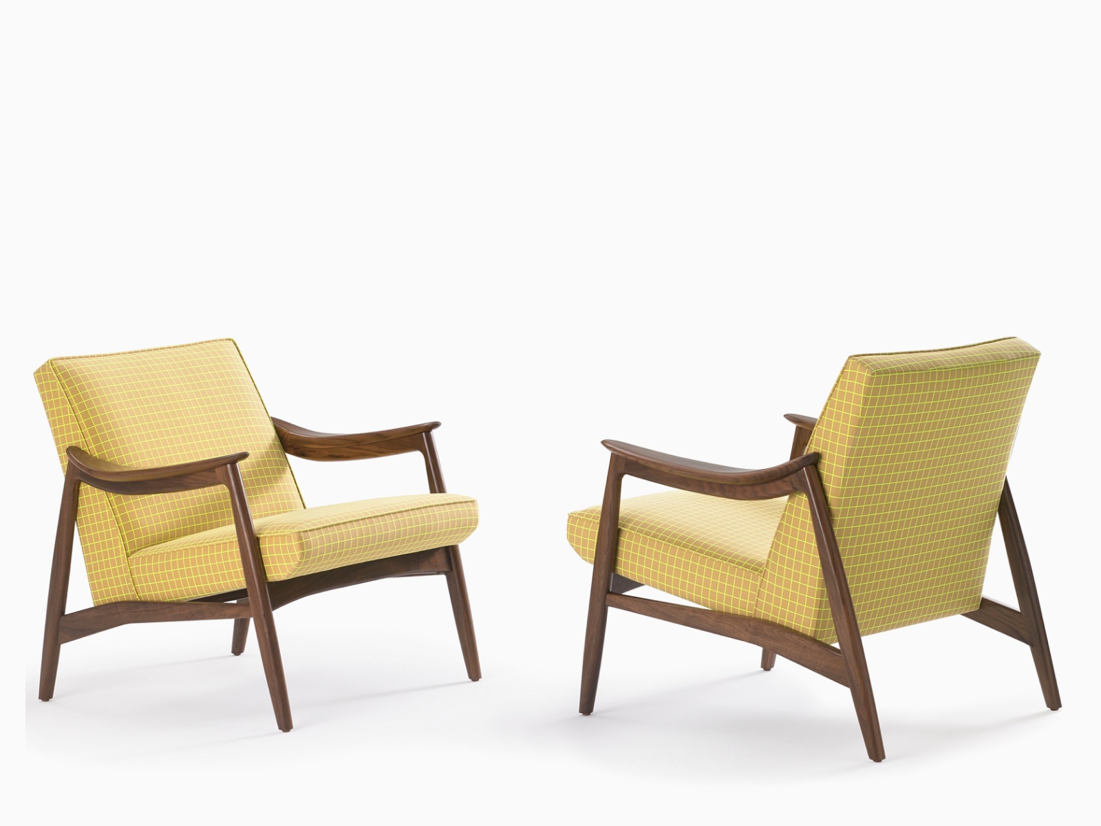 Two Aspen lounge chairs in yellow textile and walnut base.