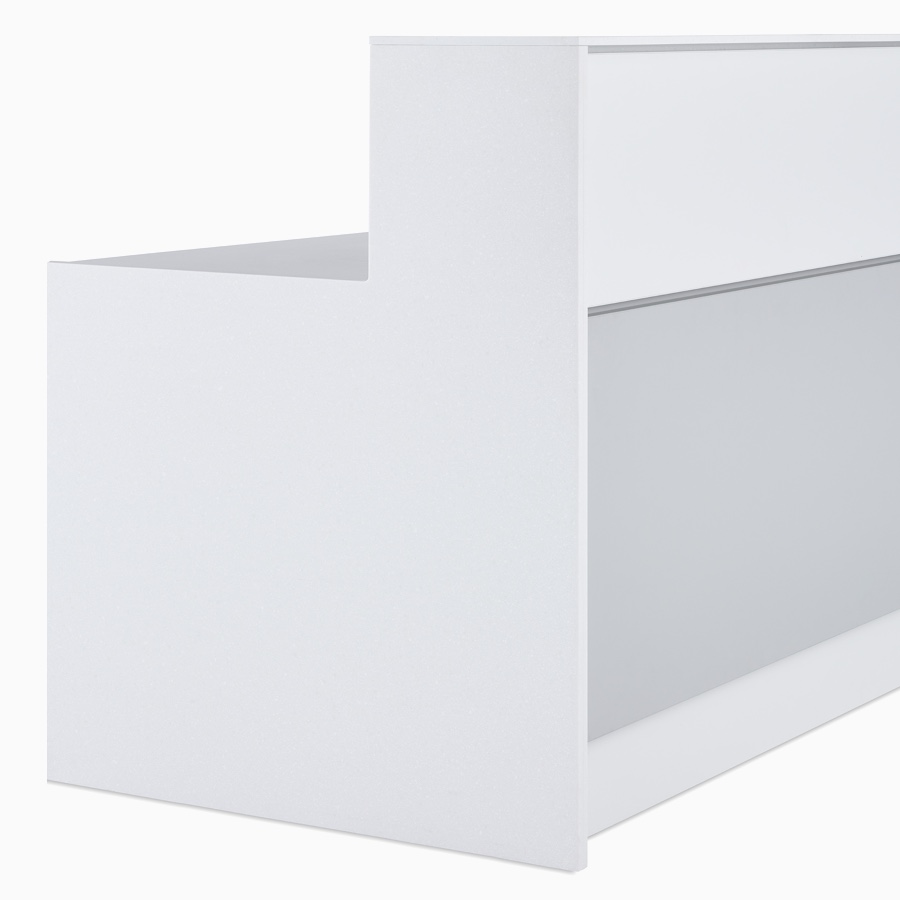 A close-up view of the gray and white two-piece exterior cladding, white laminate tops, and white Corian end panels on a prefab Commend Nurses Station.