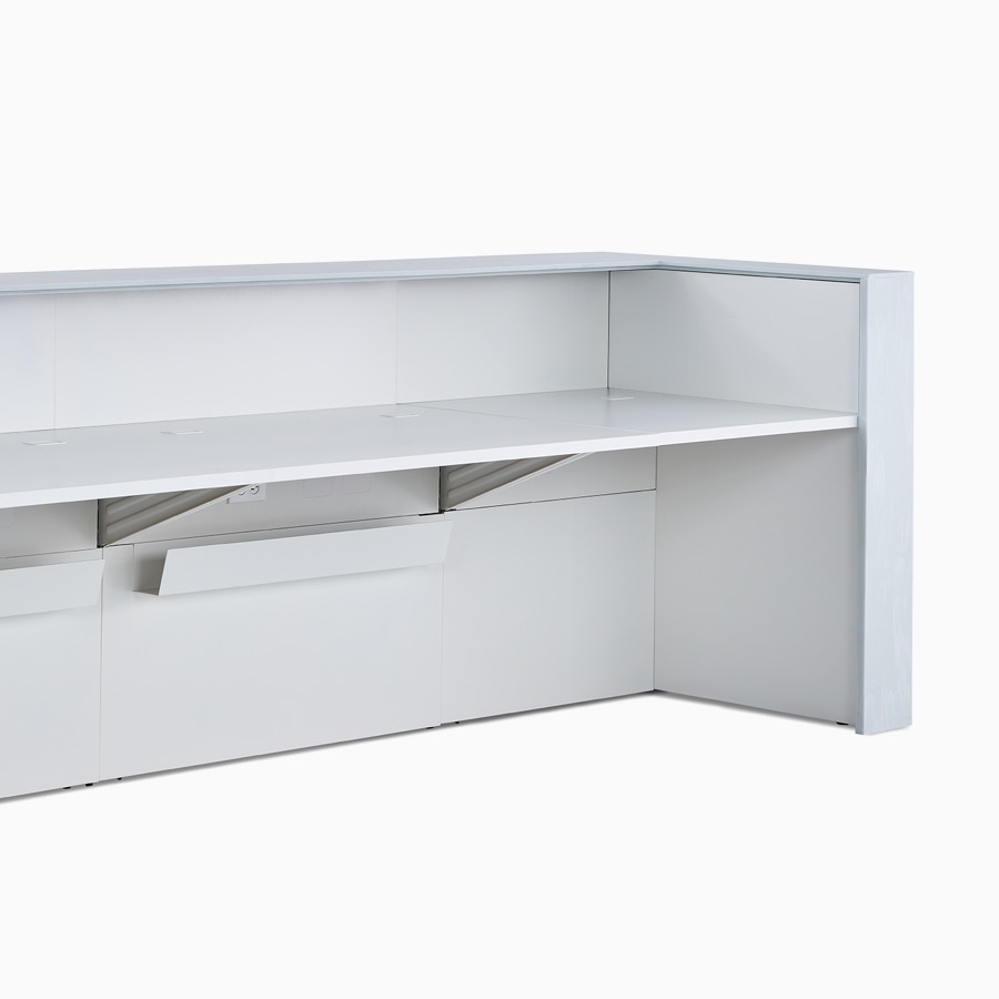 The interior of a 42 inch high Commend Nurses Station with work surfaces, off-white Corian top, and cable management troughs.