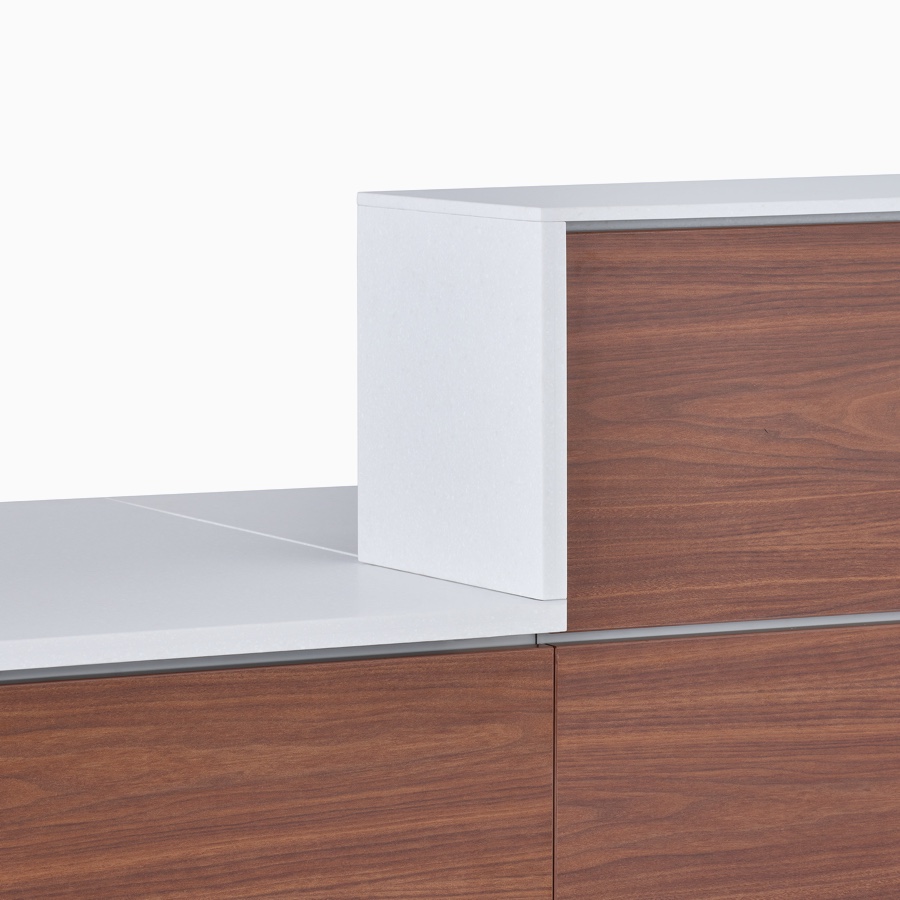 A close-up view of the level switch between the 30 and 42 inch high prefab Commend Nurses Station structures with white Corian transaction tops.
