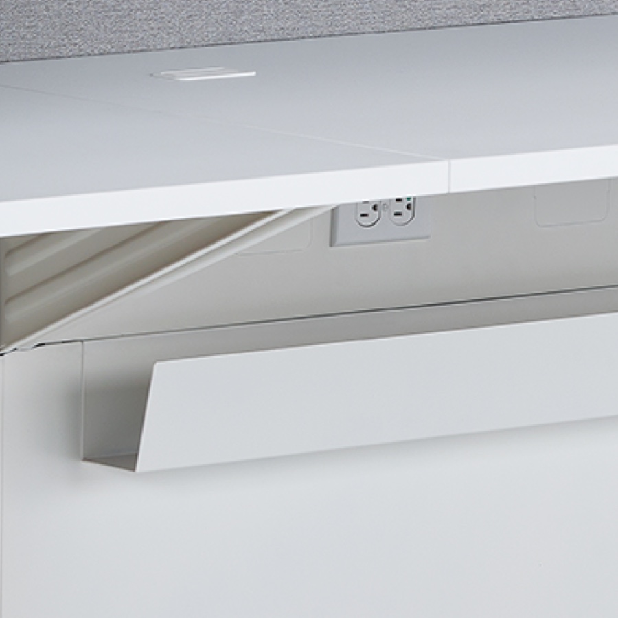 A close-up view of the power outlets and cable trough located underneath Commend Nurses Station's work surface.