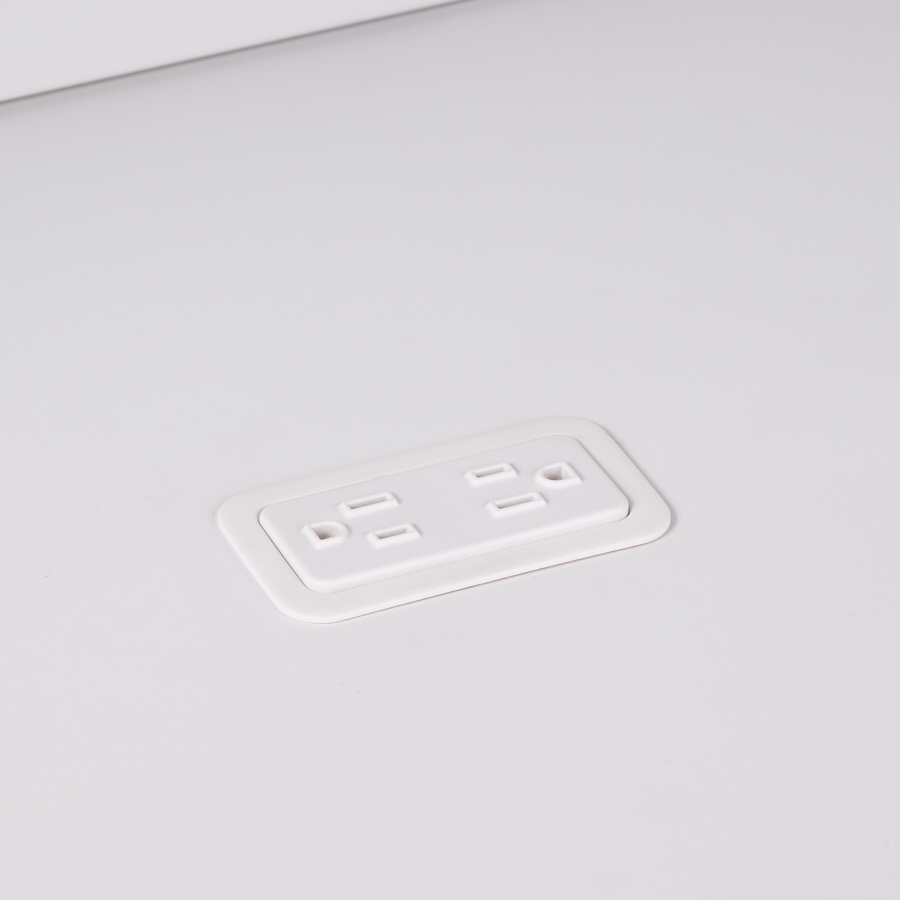 A close-up view of Logic Mini with two power outlets integrated into the top of a white laminate work surface.