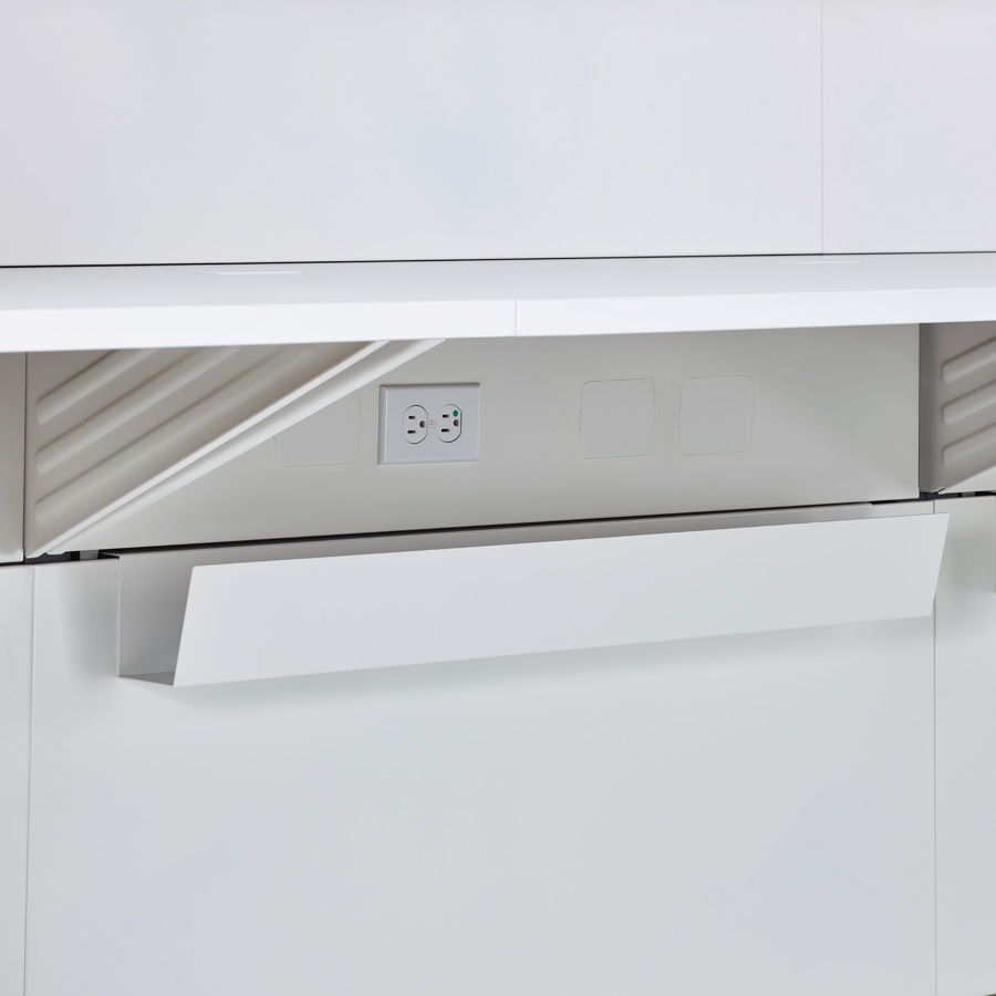 A close-up view of the power outlets and cable trough located underneath Commend Nurses Station's work surface.