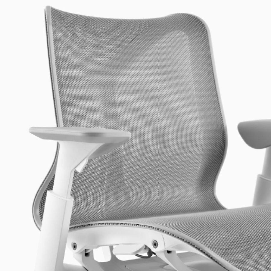 A low-back Cosm Chair with height-adjustable arms and Studio White frame and Mineral suspension material.