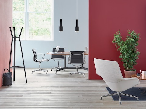 Black mid-back Eames Aluminum Group office chairs in a meeting room.