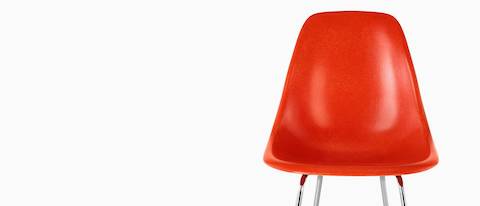 Upper half of a red Eames Molded Fiberglass Stool, viewed from the front. 