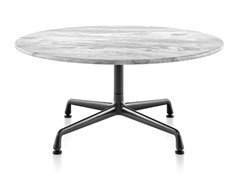 A round Eames outdoor table with a white marble top and black base.