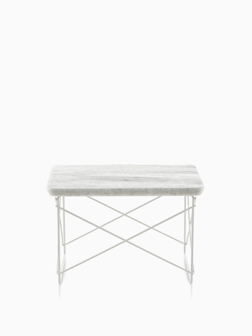 An Eames Wire Base low outdoor table with a stone top.