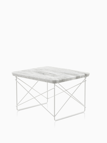 An Eames Wire Base low outdoor table with a stone top. select to go to the Eames Wire Base Low Table Outdoor product page.