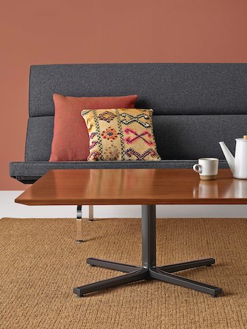 Ein Everywhere Table in Walnut vor einem Eames Kompaktsofa.