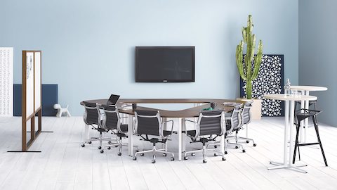 Una sala de reuniones con negro Eames Aluminum Group Sillas alrededor de Everywhere mesas de conferencias en una configuración de triángulo.