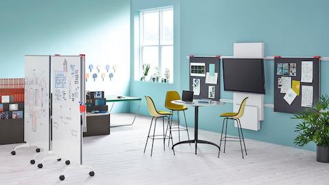 A collaboration space featuring a table, media tile, display boards, and mobile carts from Exclave.